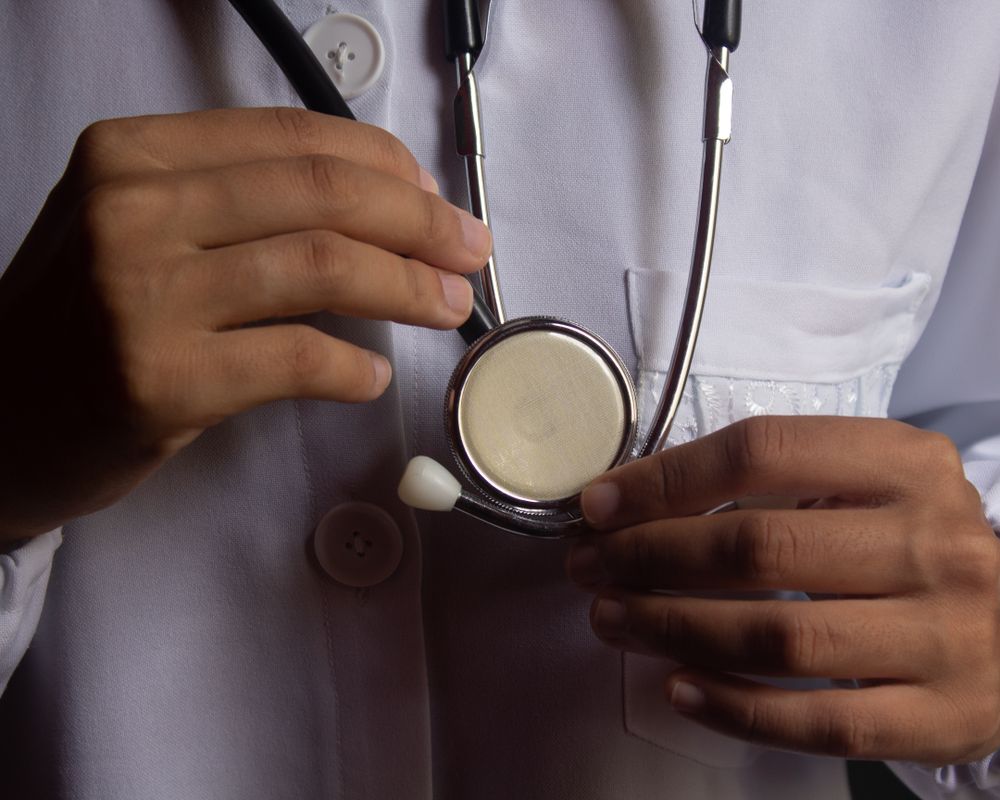 Physician preparing a stethoscope for patient care
